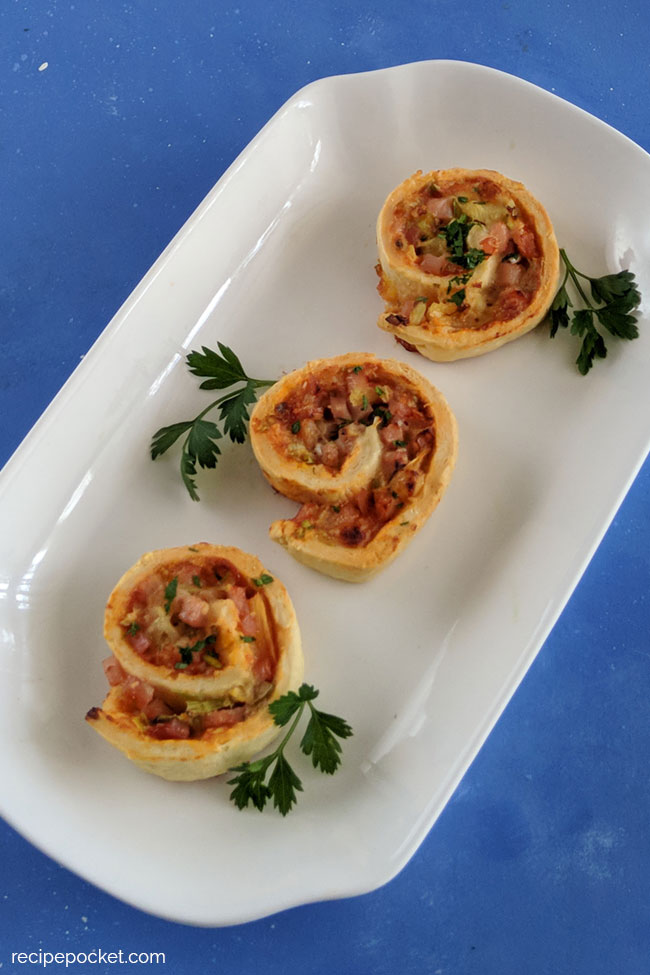 Baked ham and cheese pinwheels on a white plate