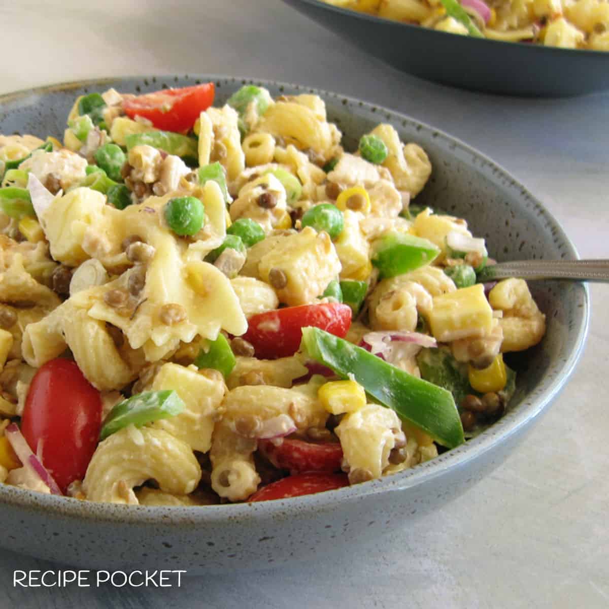 Cold pasta salad in a blue grey bowl.