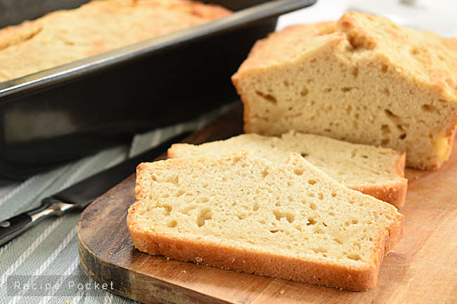 Image showing beer bread on a cutting board and a loaf in a baking pan.
