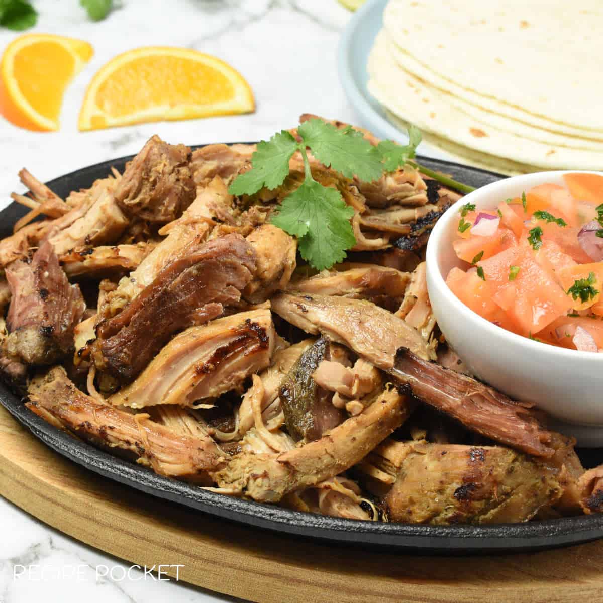 A dish filled with slow cooker pulled pork with a bowl of diced tomatoes.