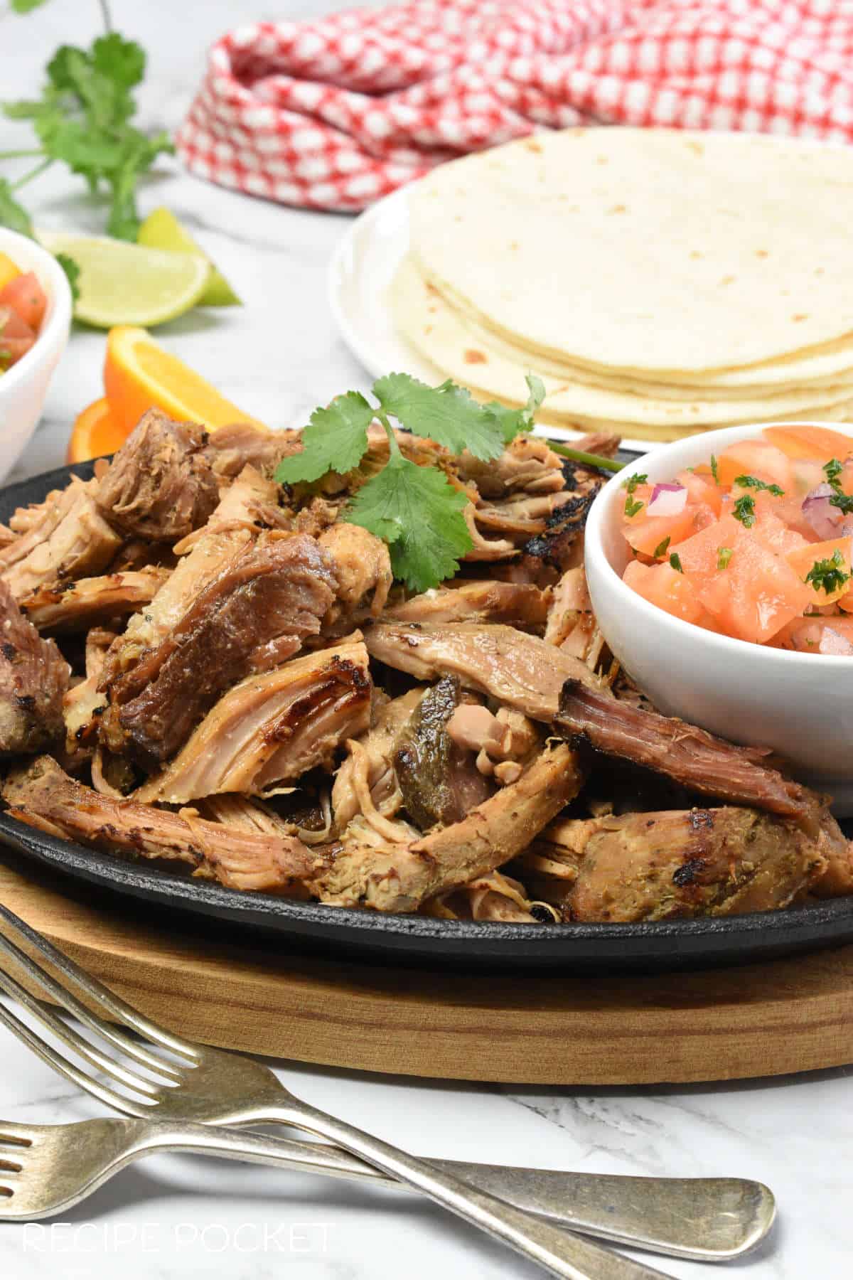 PUlled pork with a stack of toritllas in the background.