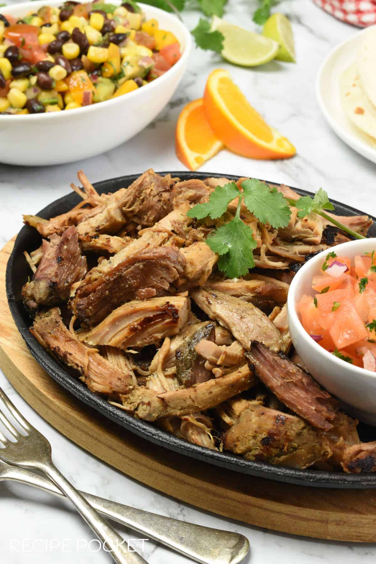 Pulled pork with a bowl of corn salsa in the background.