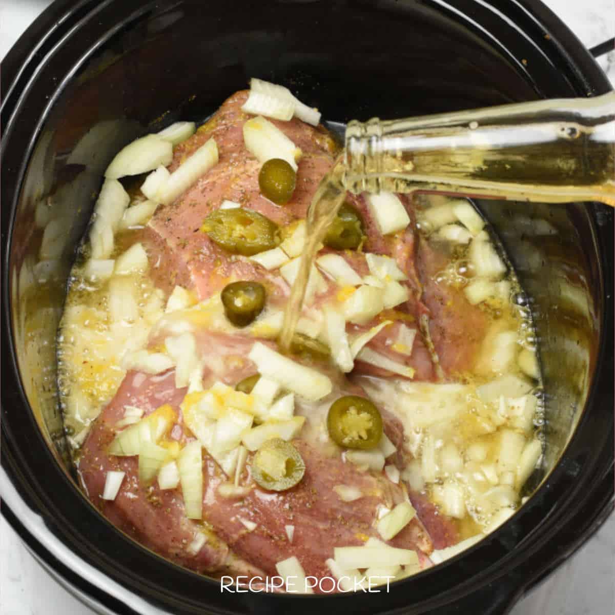 Beer being poured over meat in a slow cooker.