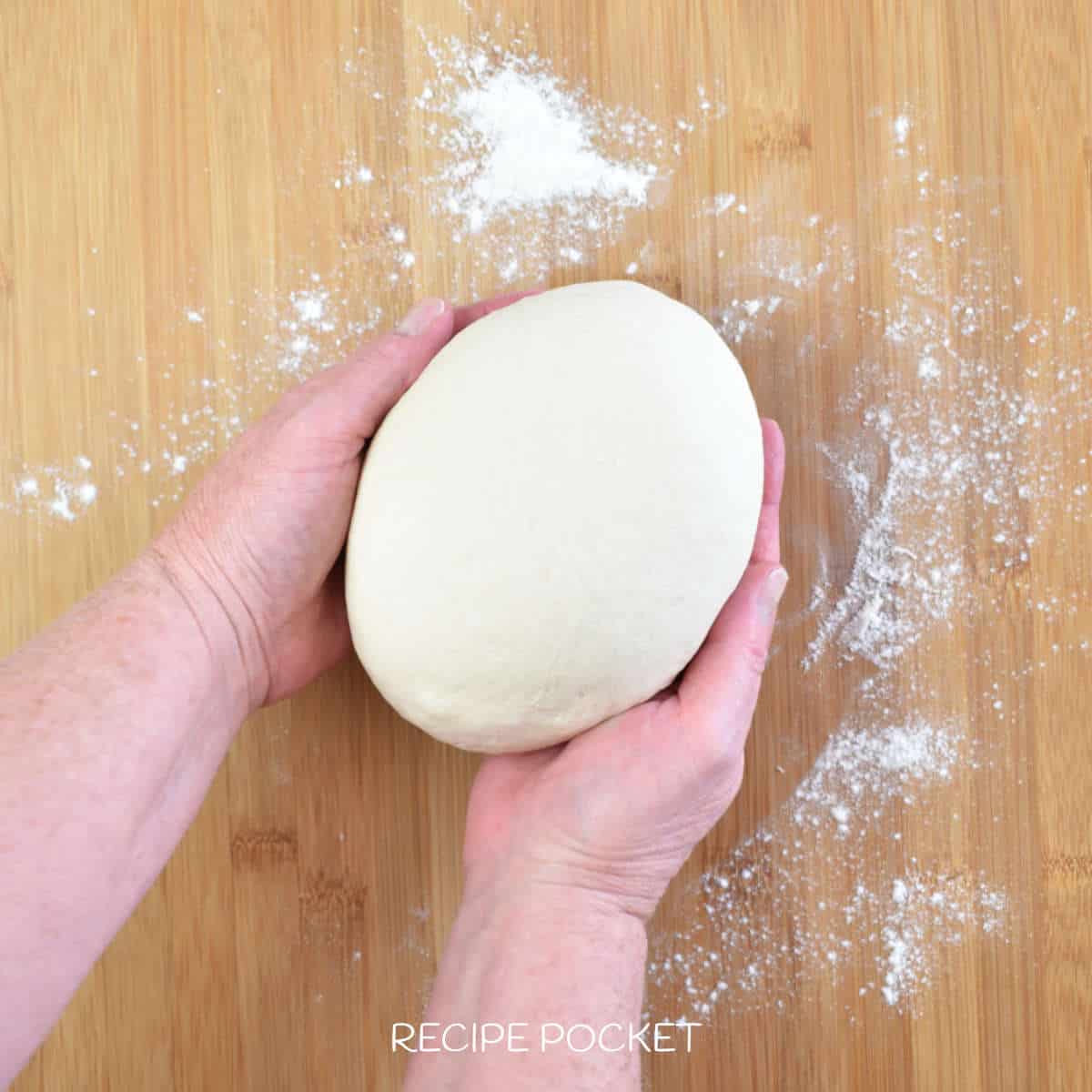 Dough being shaped into a smooth bal.