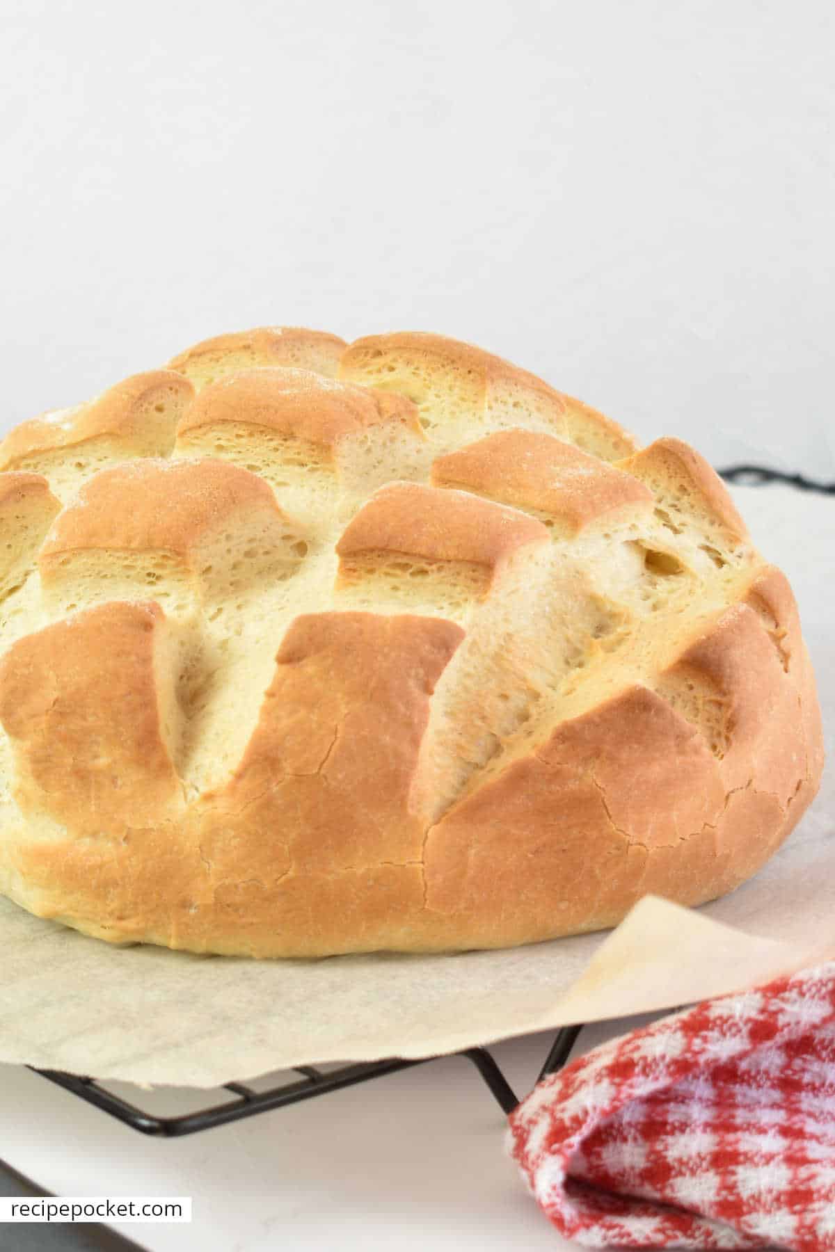 Freshly baked cob bread on parchment paper and cake rack.