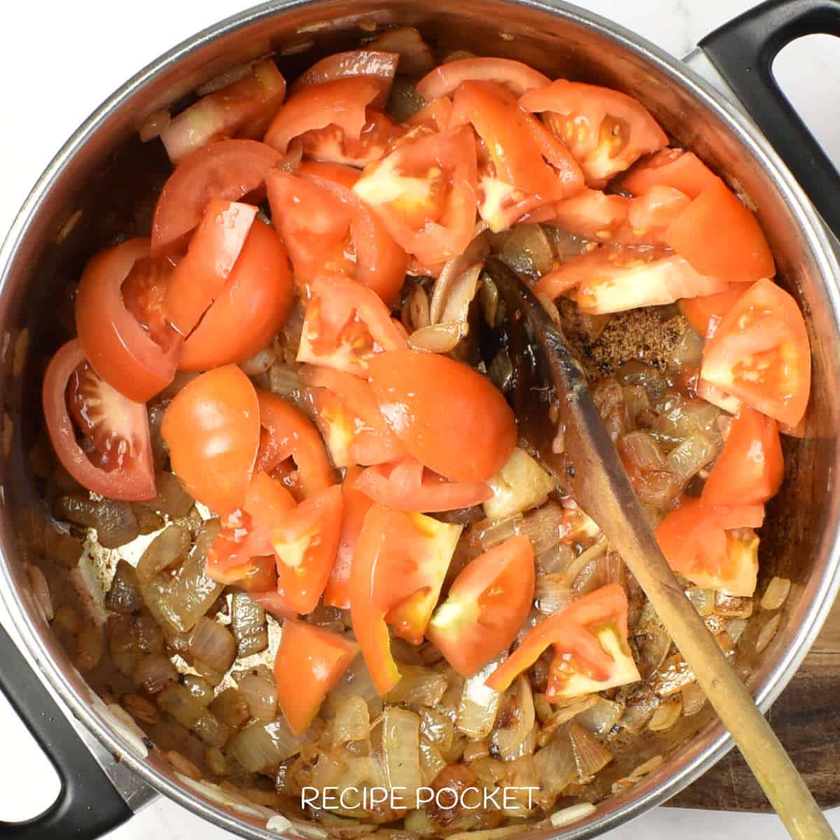 Onions and tomato in a pan.