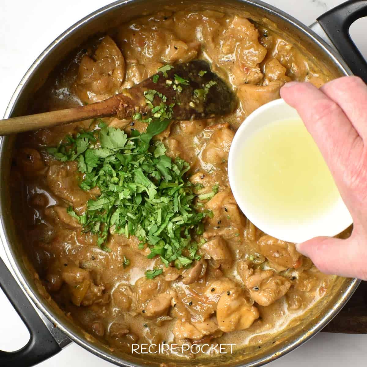 Lemon juice and herbs added to a pot with cooked chicken.