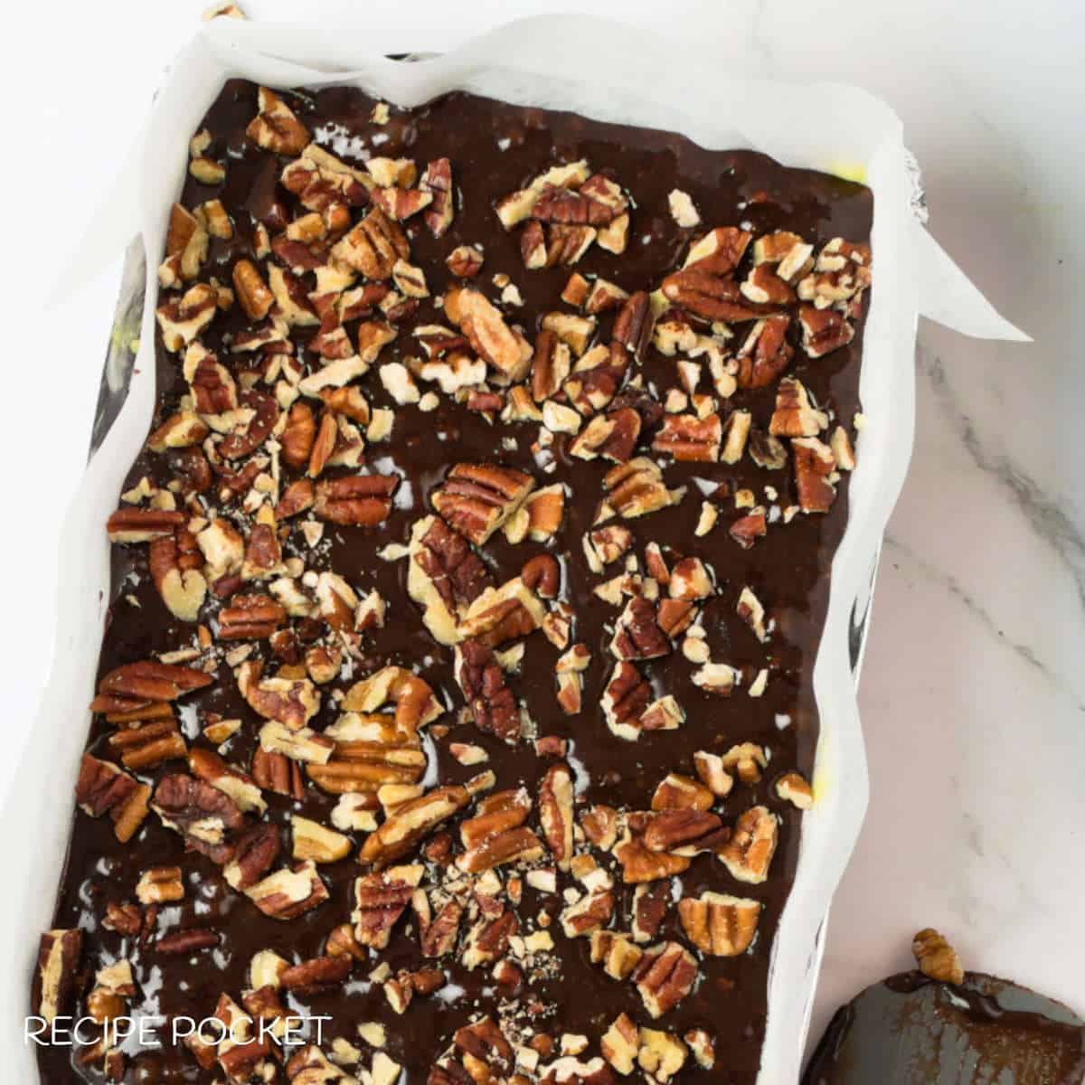 Chopped pecans on brownie batter before baking.