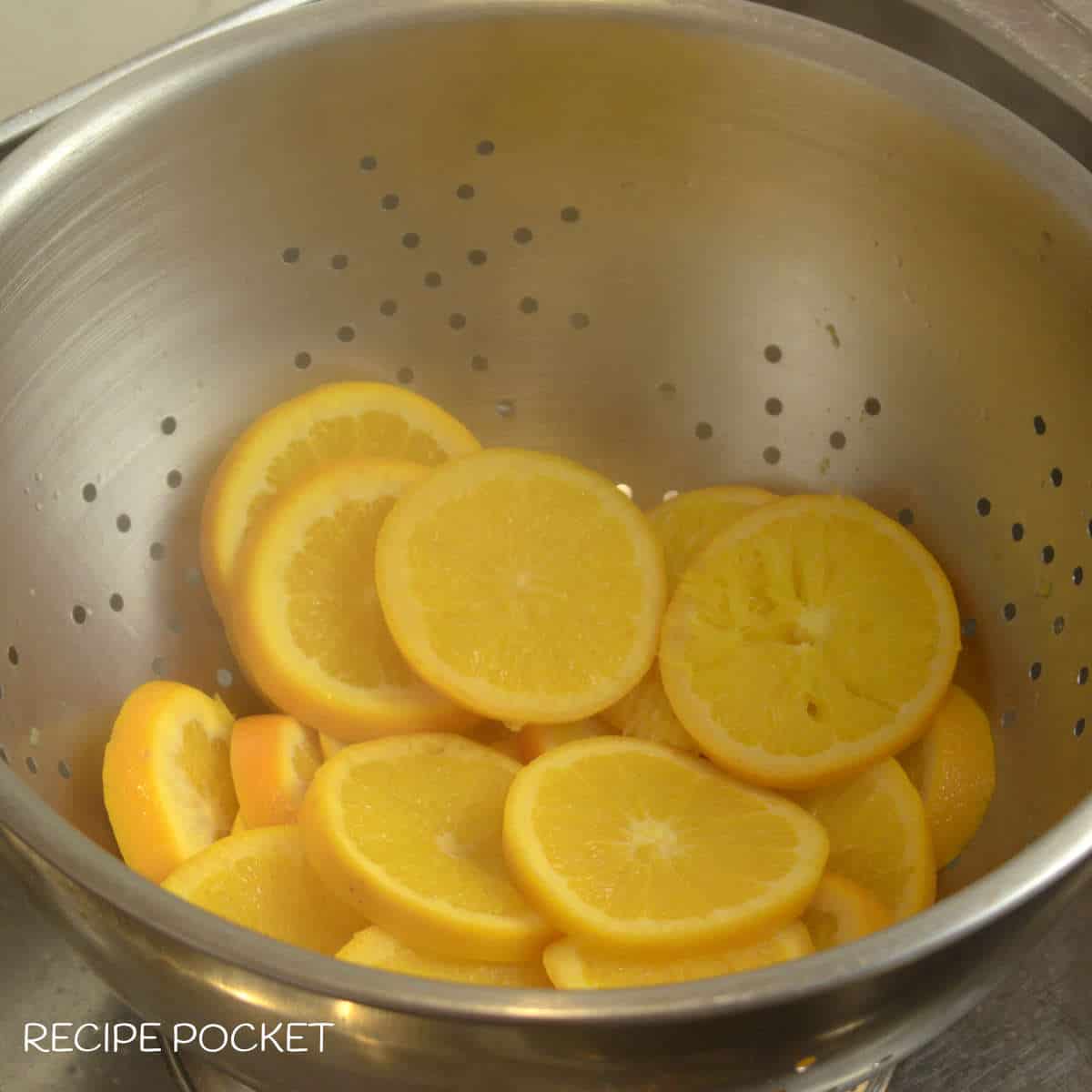 Cooke orange slices in a colander.
