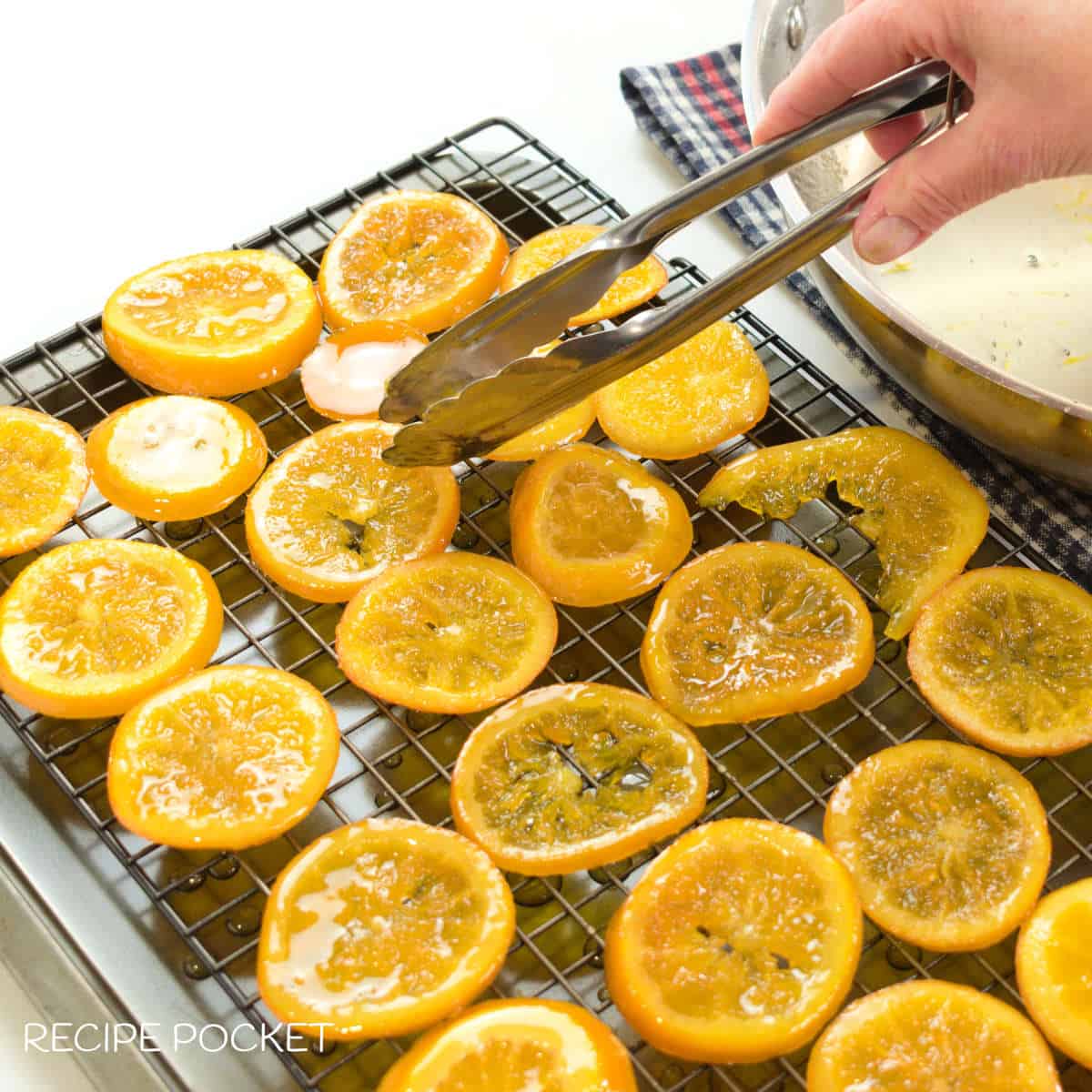 Freshly made candied orange slices drying on a cake rack.