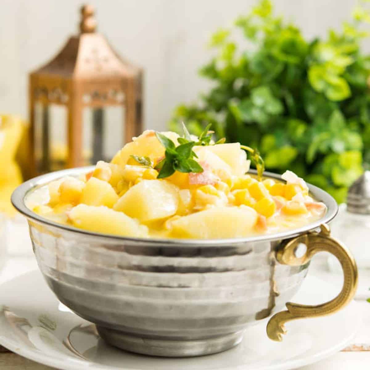 Chunky potato soup served in a metal cup.