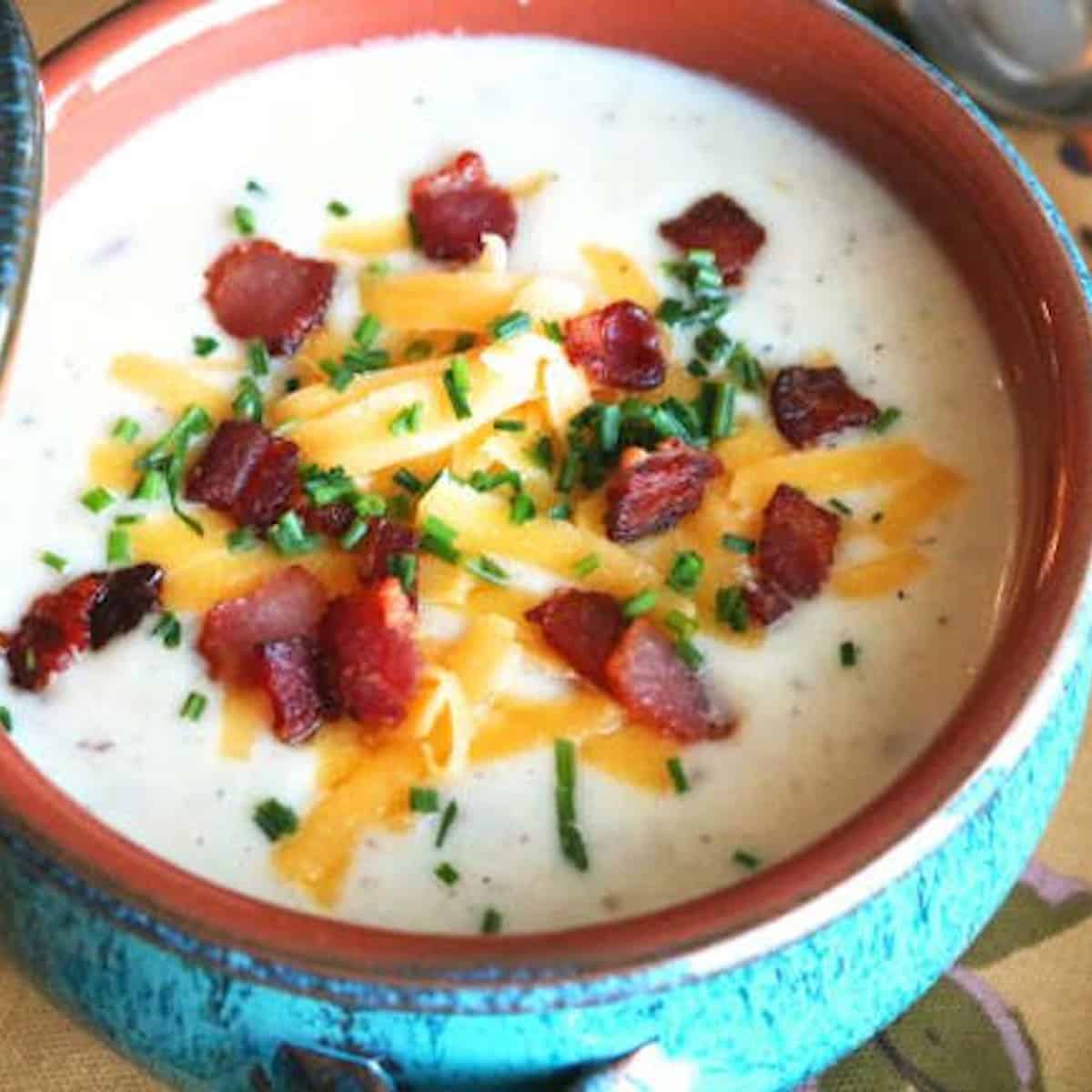 Potato and leek soup in a blue bowl.