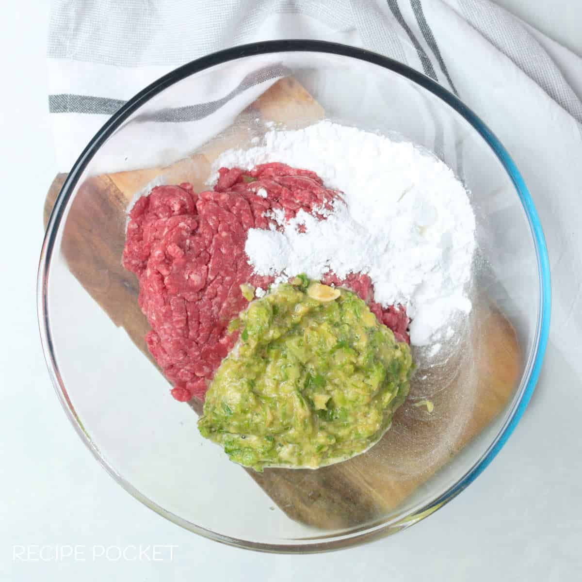 Ground beef and other ingredients in a mixing bowl.