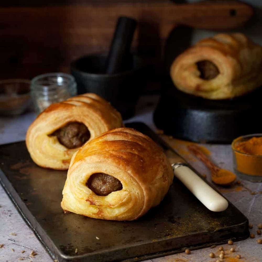 Lamb sausage rolls on a baking tray.