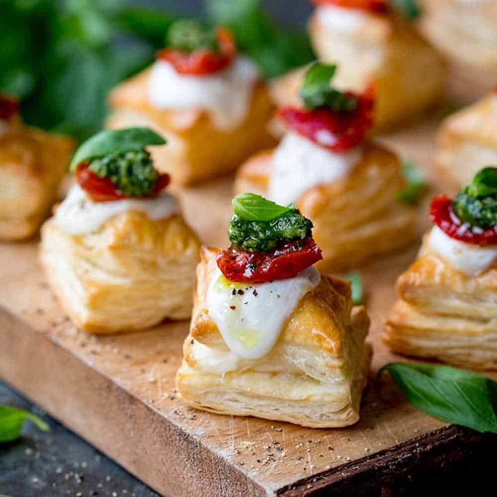 Puff pastry squares with cheese and sundried tomatoes on top.