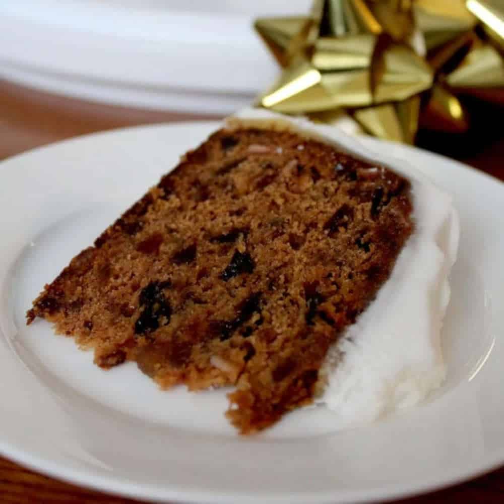 A slice of Christmas fruit cake on a plate.