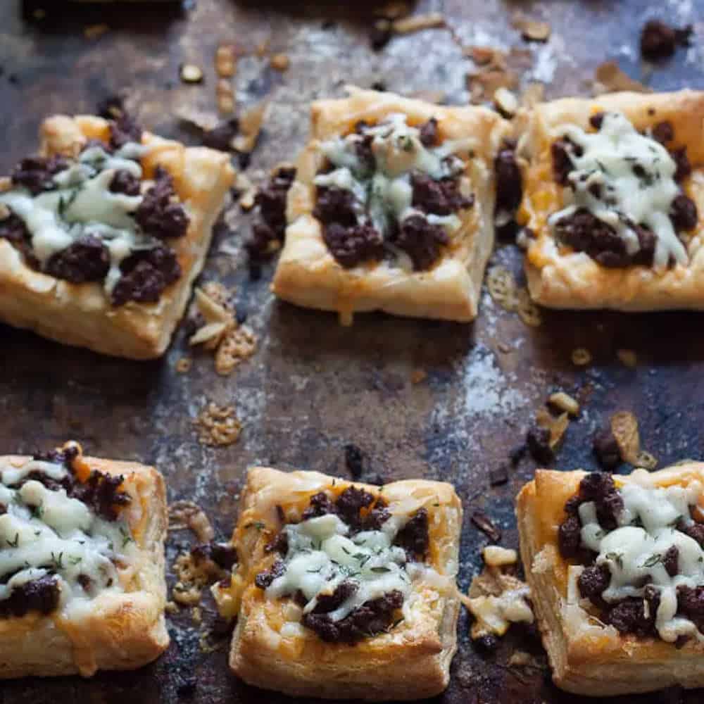 Chorizo and thyme tarts on a baking tray.