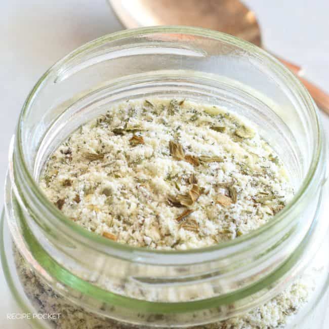 Dry ranch dressing mix with a spoon in the background.