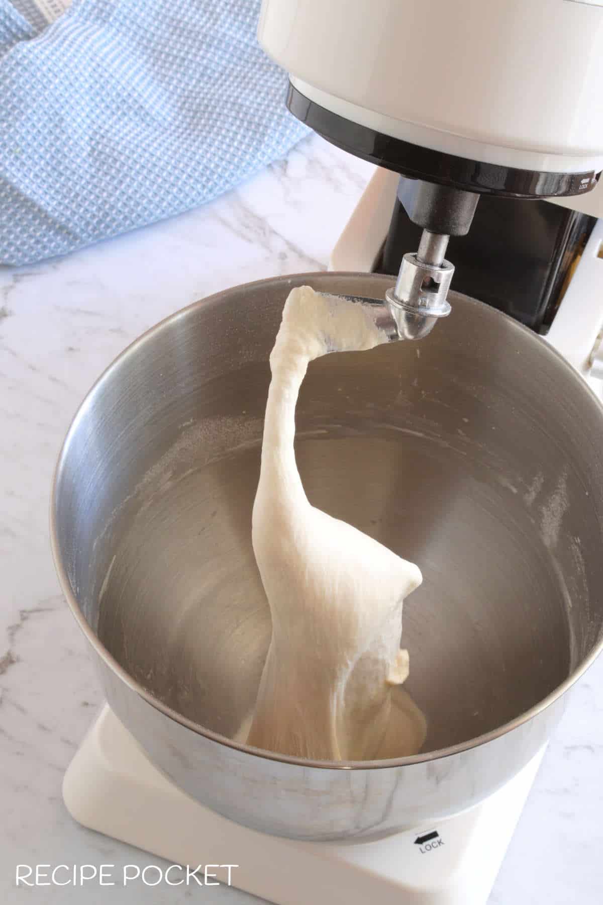 Pizza dough in a stand mixer.