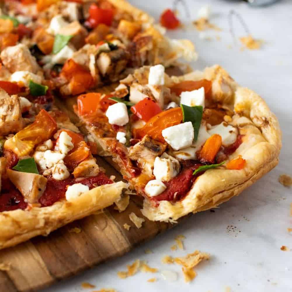 Tomato and cheese puff pastry pizza. on a board.