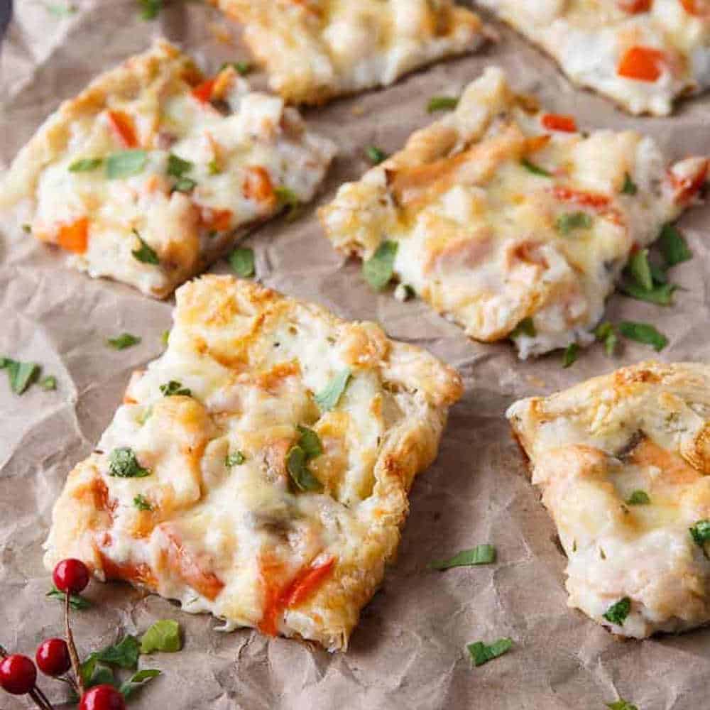 Seefood pizza pieces on a piece of baking paper.