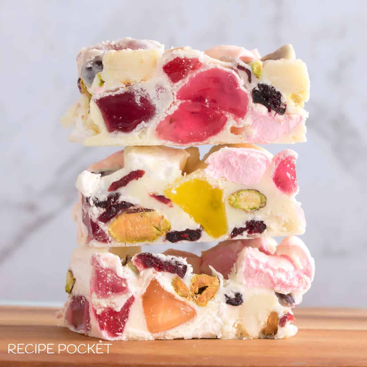 A stack of rocky road on a wooden board.