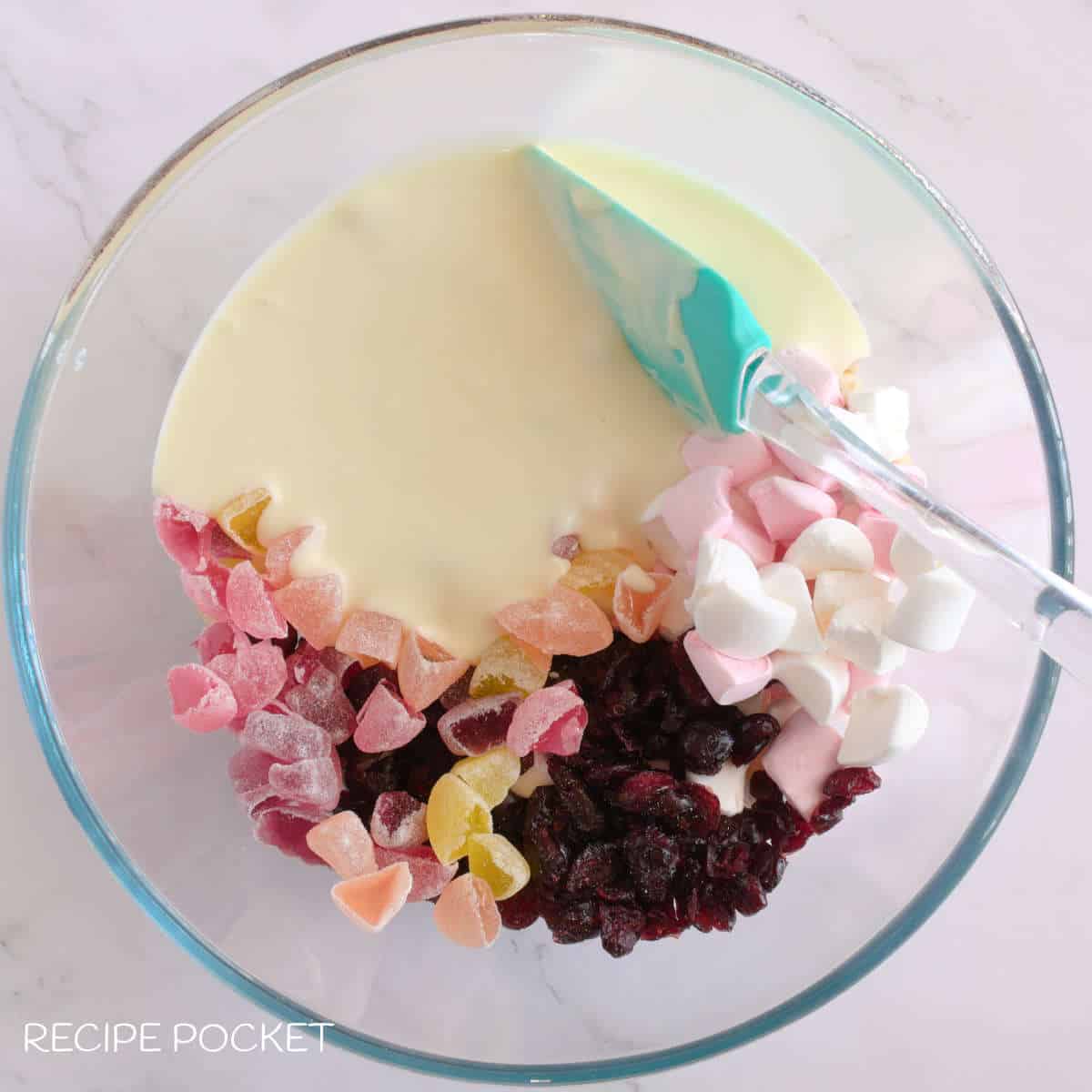 Melted white chocolate and other sweet ingredients in a mixing bowl.