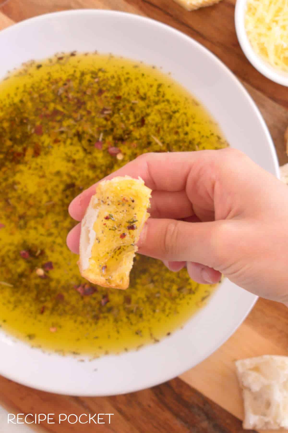 A close up image showing the dipping oil on a piece of bread.