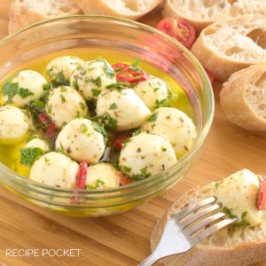 A close up of mozzarella balls in a glass bowl.
