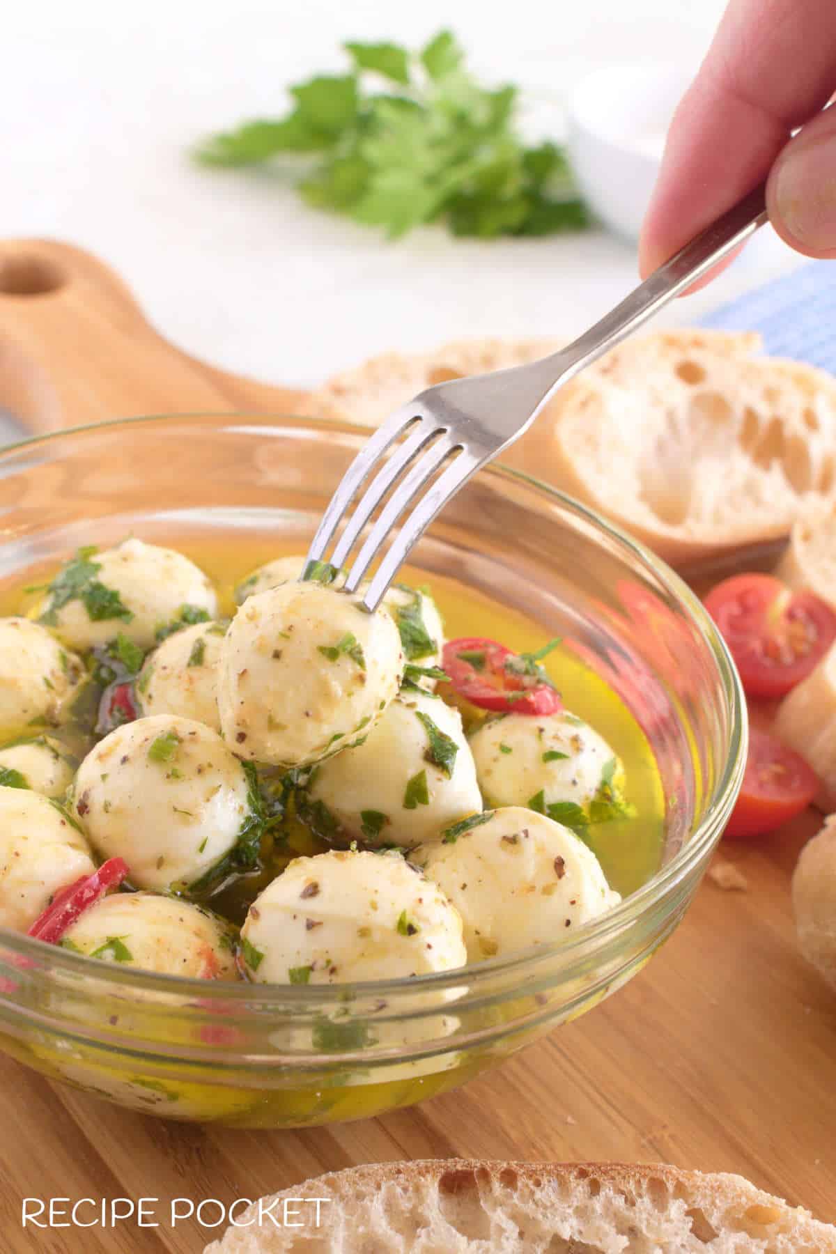 A marinated mozzarella ball on a fork.