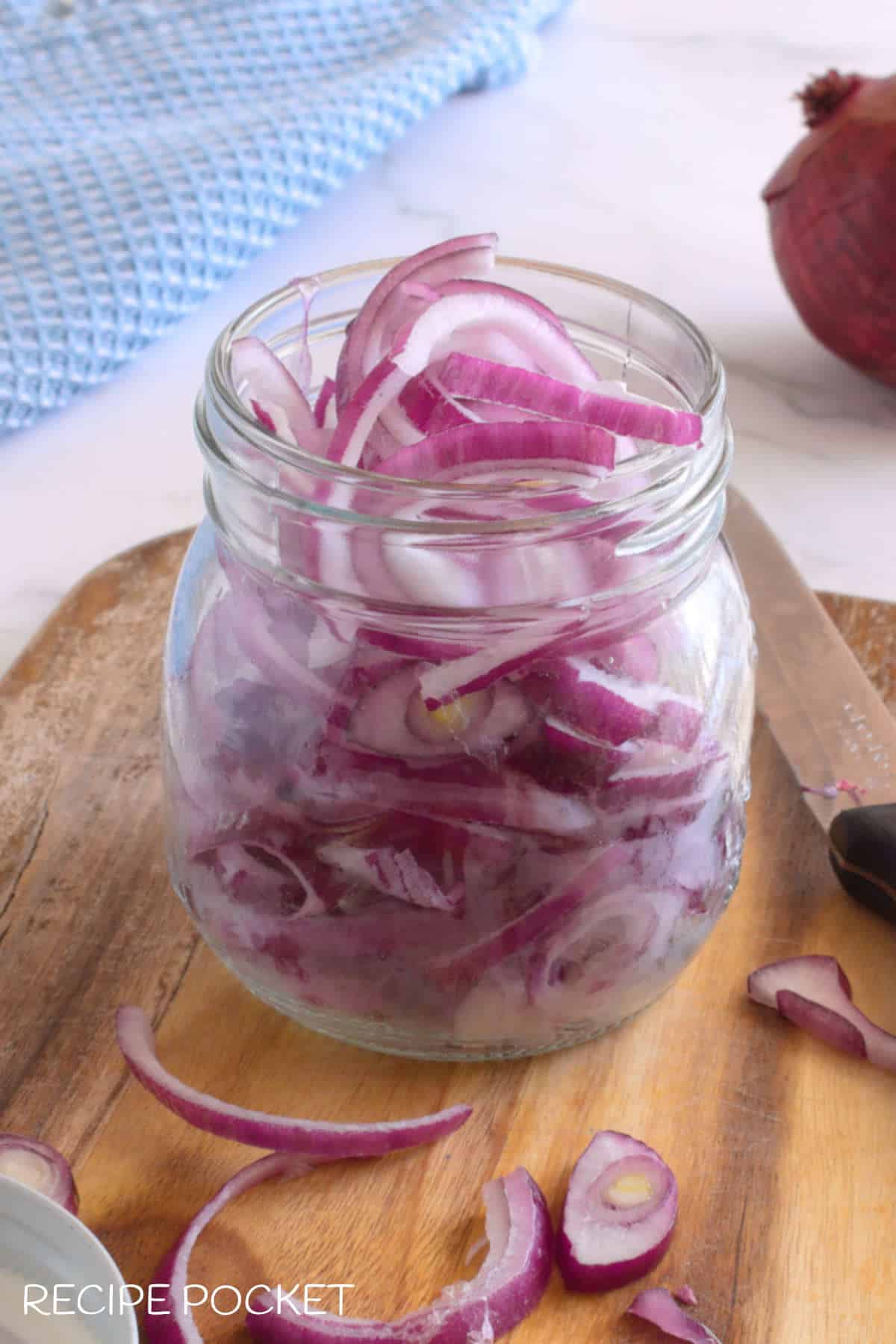 Sliced red onion in a glass jar.