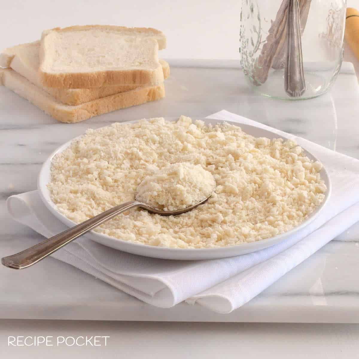 Homemade panko breadcrumbs substitute on a white place with a spoon.