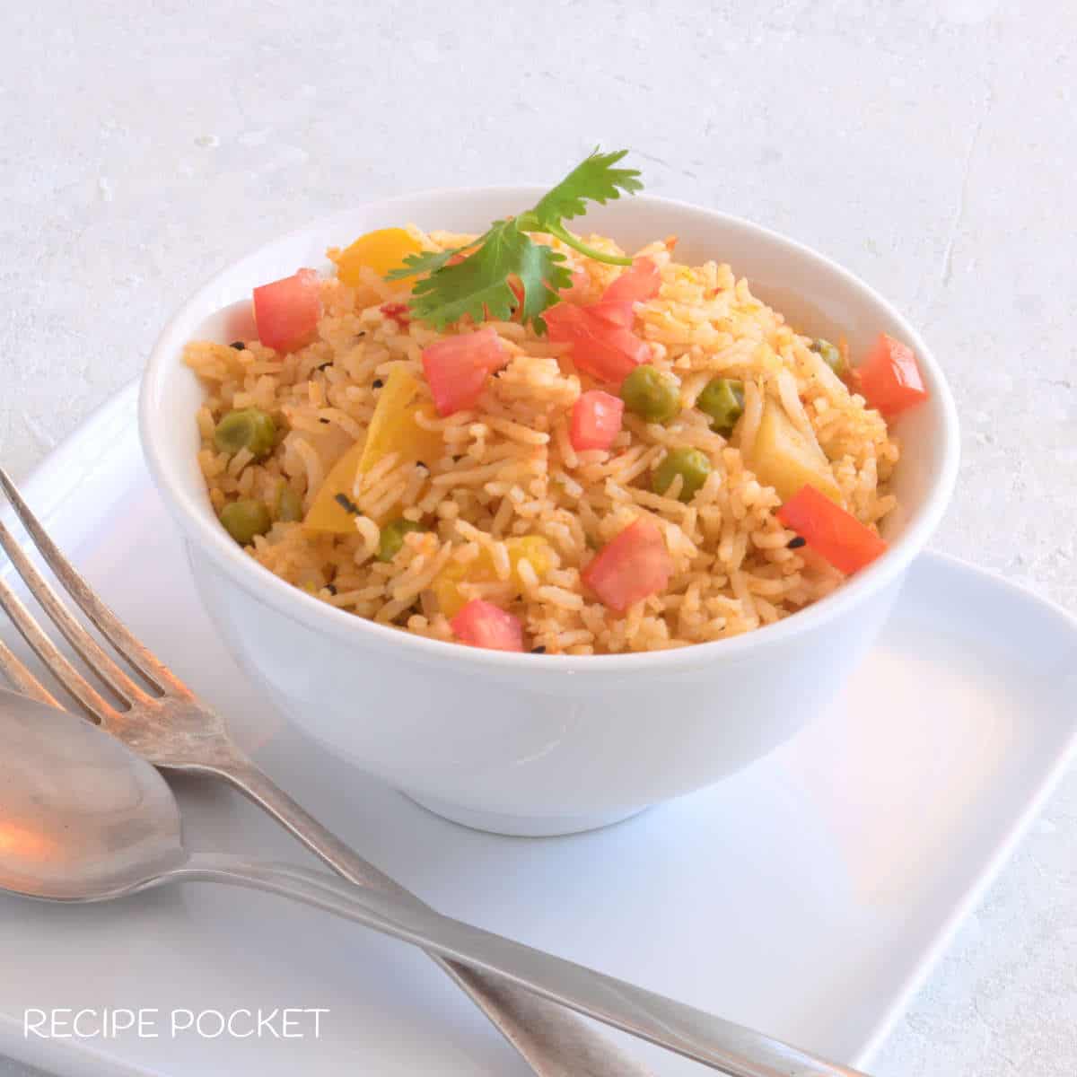 Indian spicy rice in a white bowl.