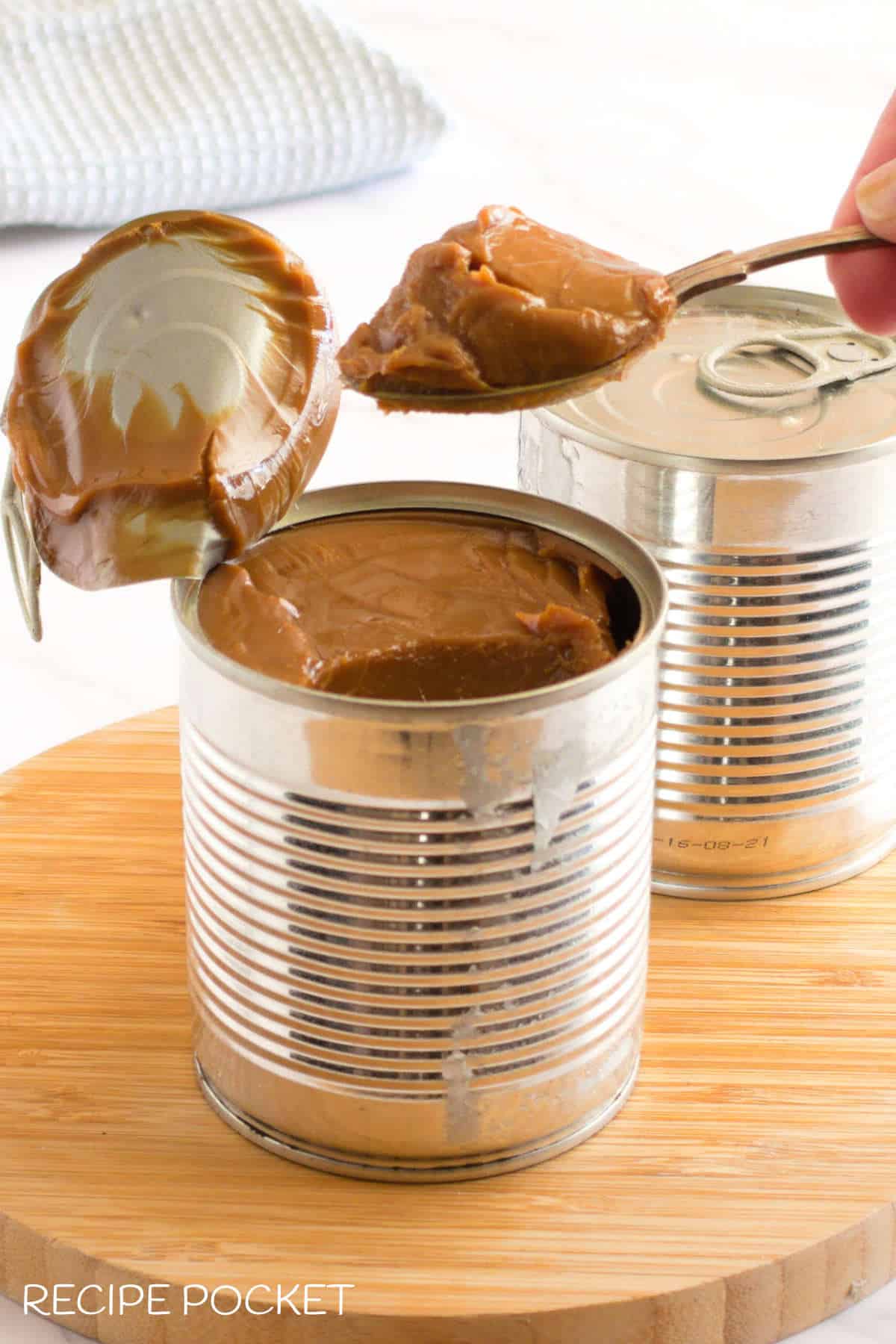 A spoon with a scoop of caramel sauce straight from the tin.