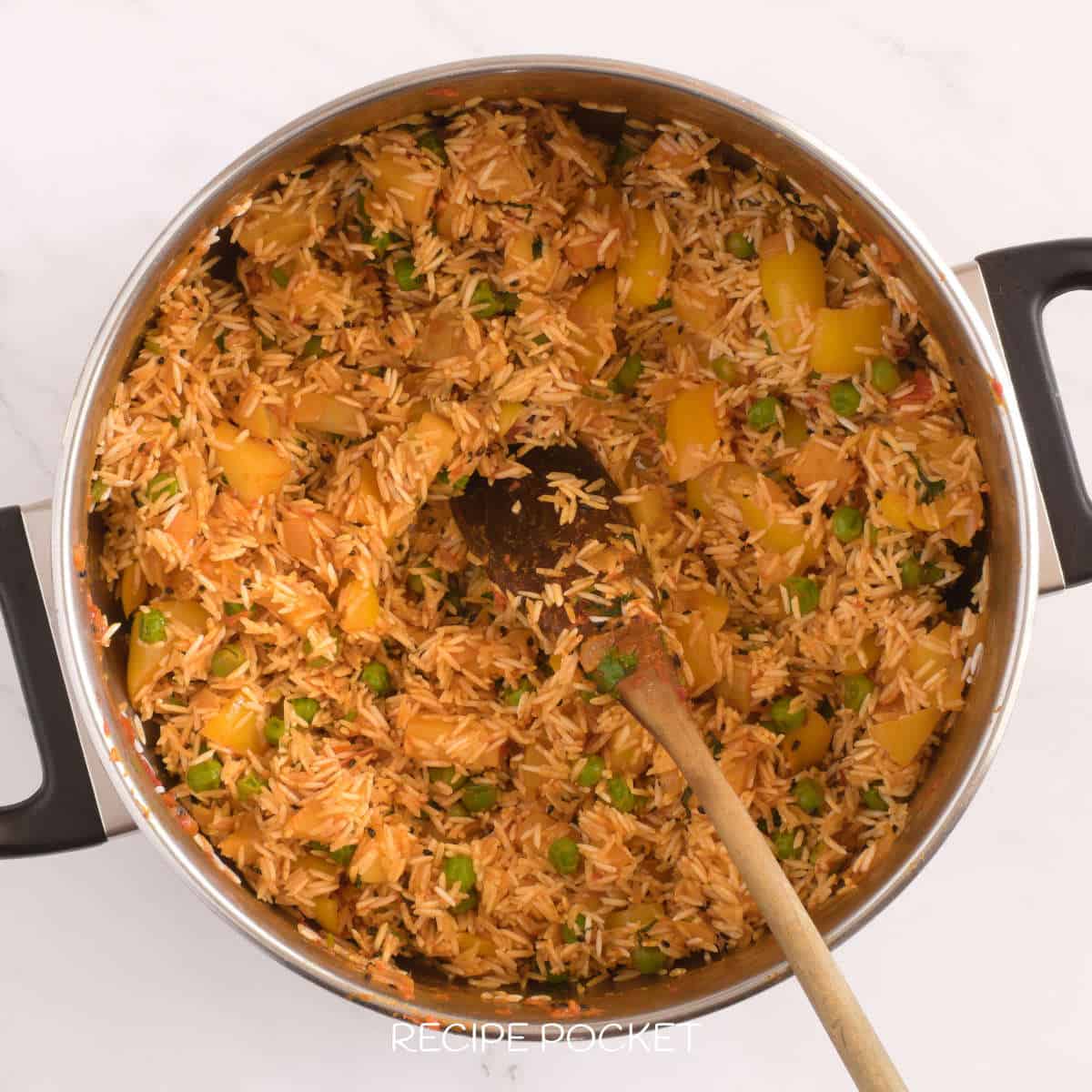 Uncooked rice coated in tomato and vegetable mixture.