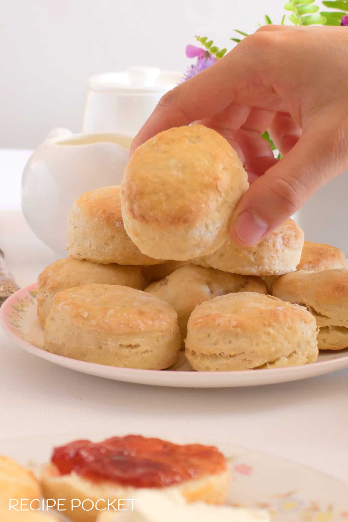 A hand picking up a scone.