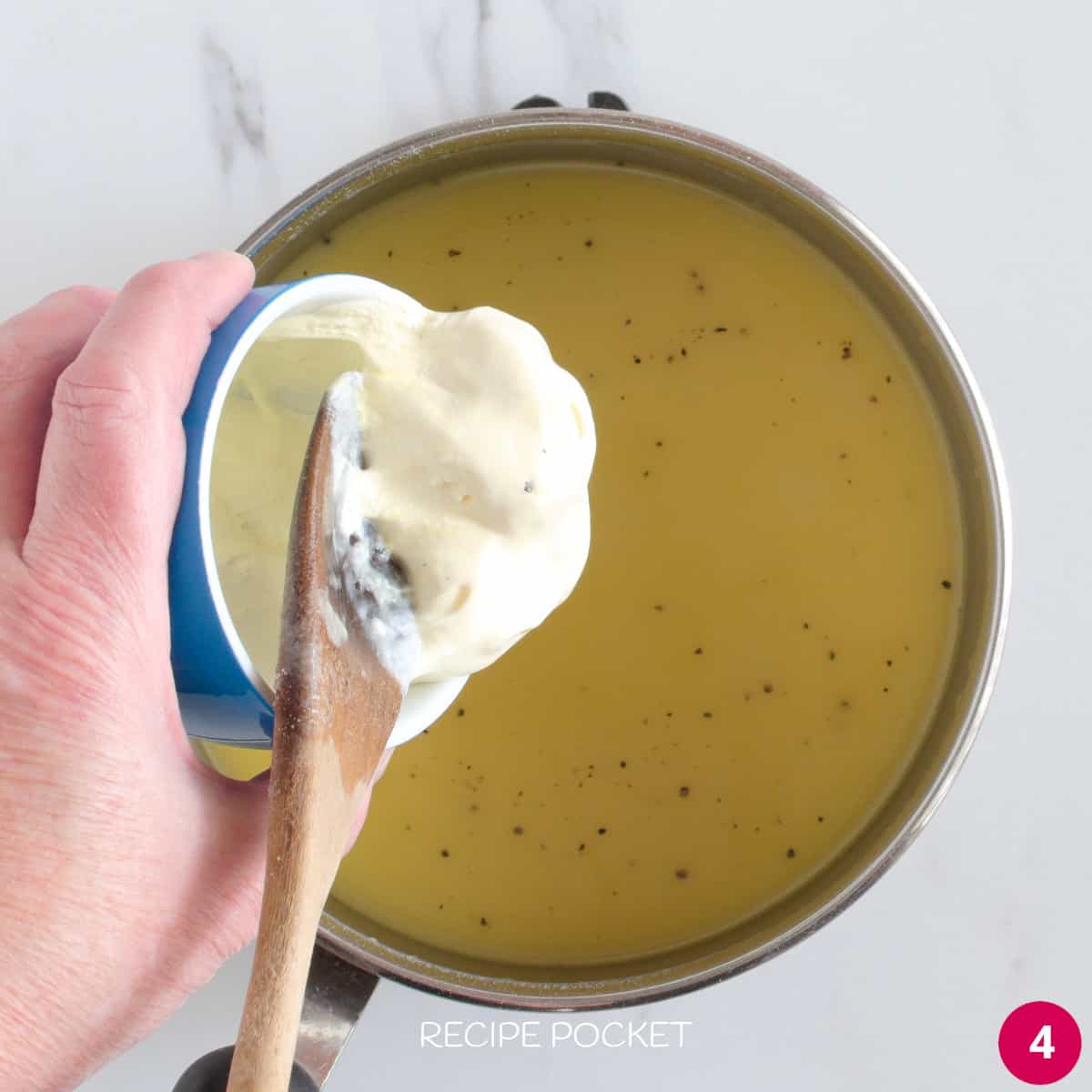Sour cream is being added to a sauce.