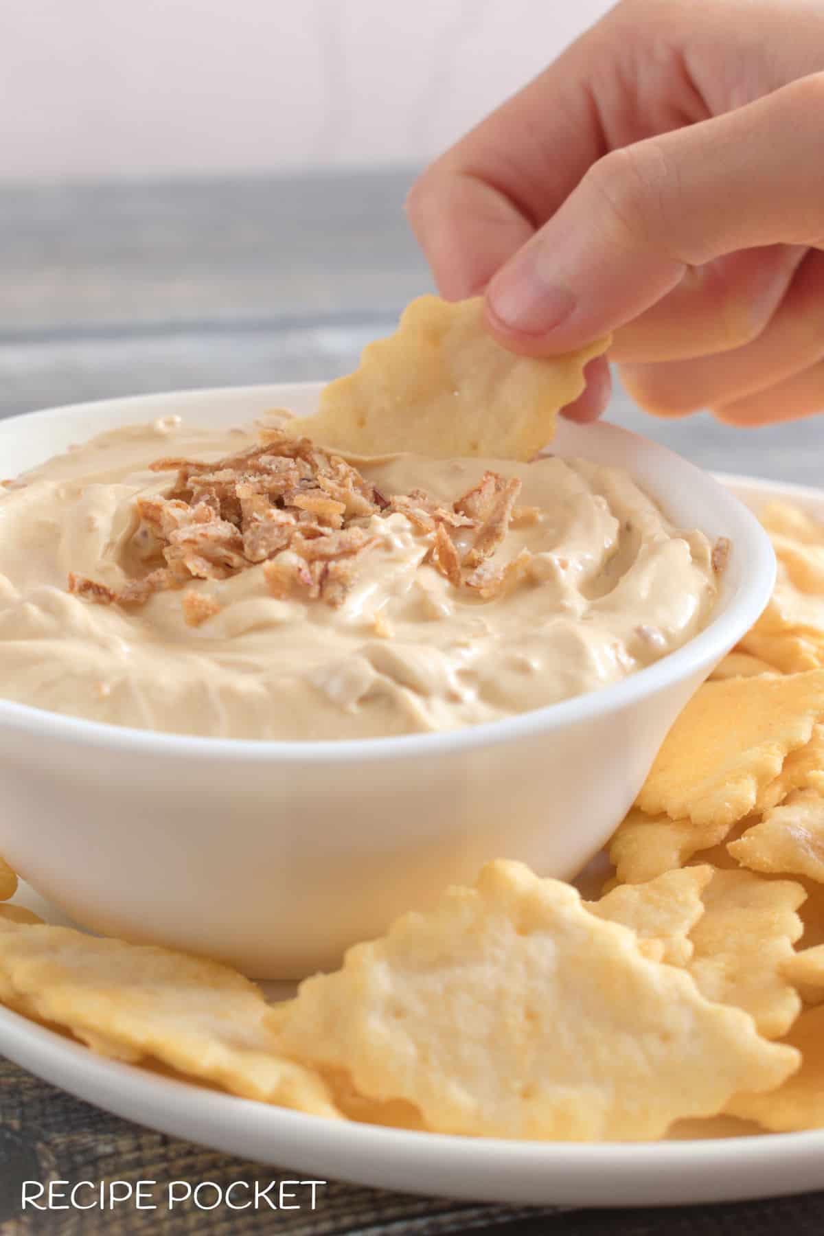 Cracker being dipped into a dip.
