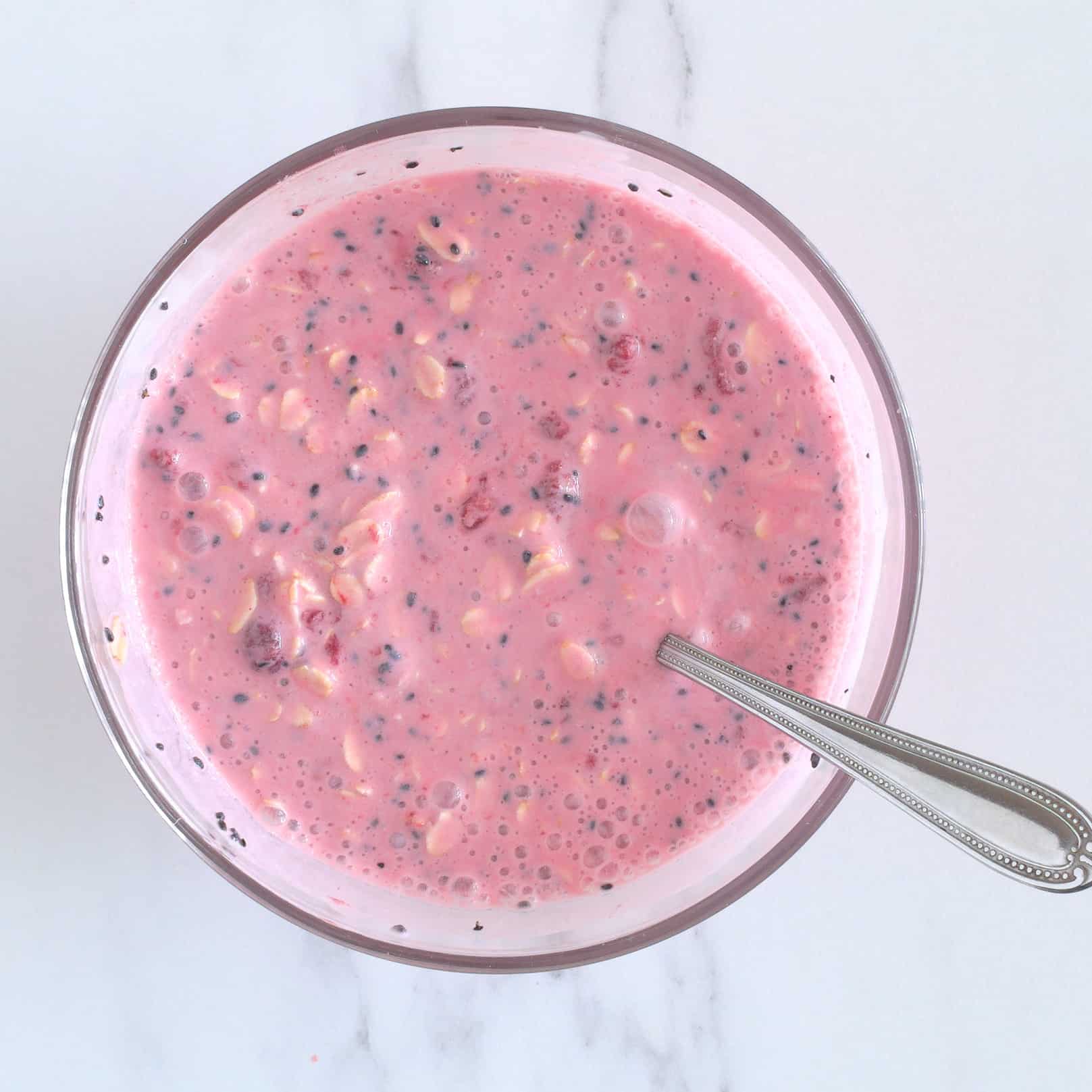 Mashed raspberries mixed into oats and milk.