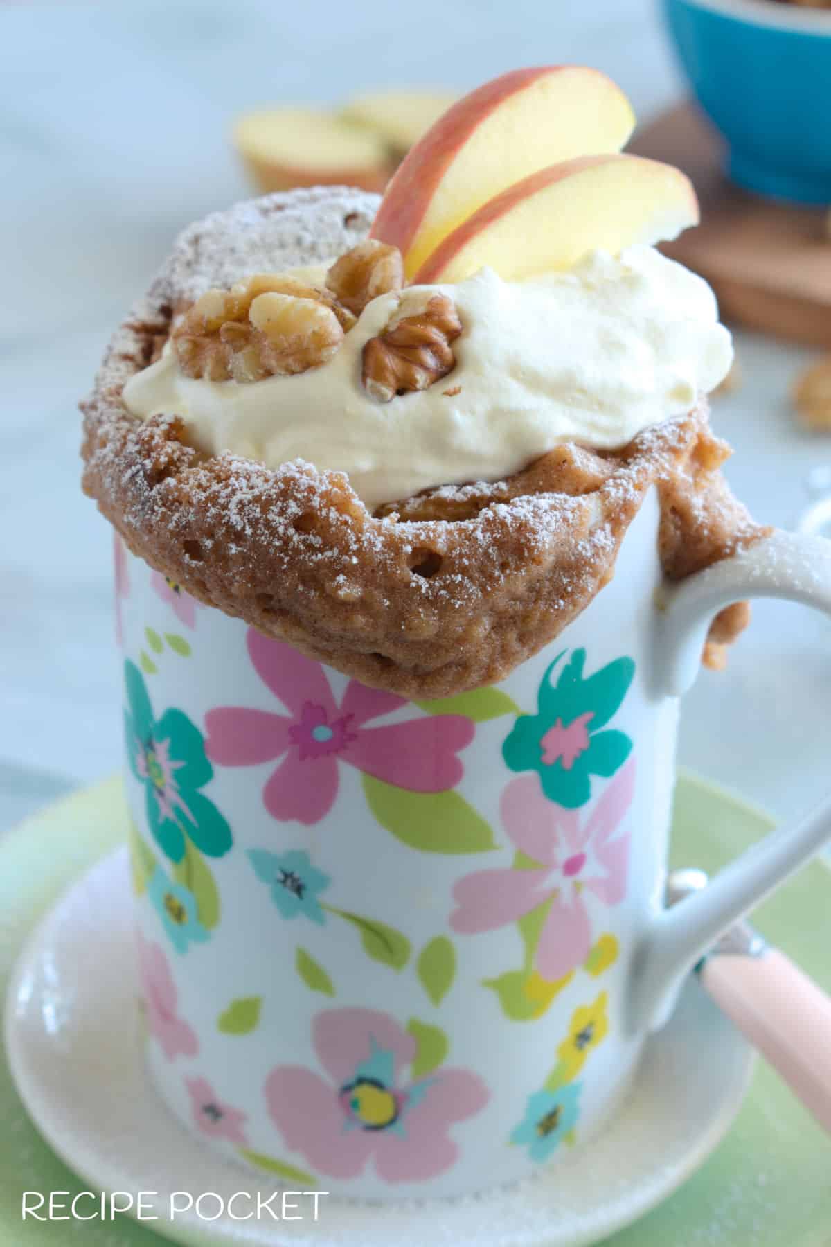 Apple mug cake in a pink and blue flower mug.