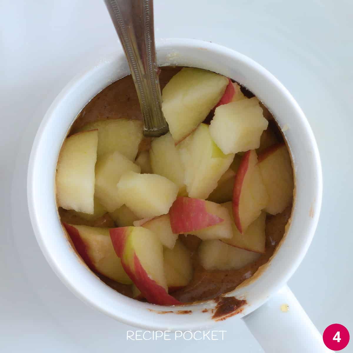 Diced apple in mug cake batter.