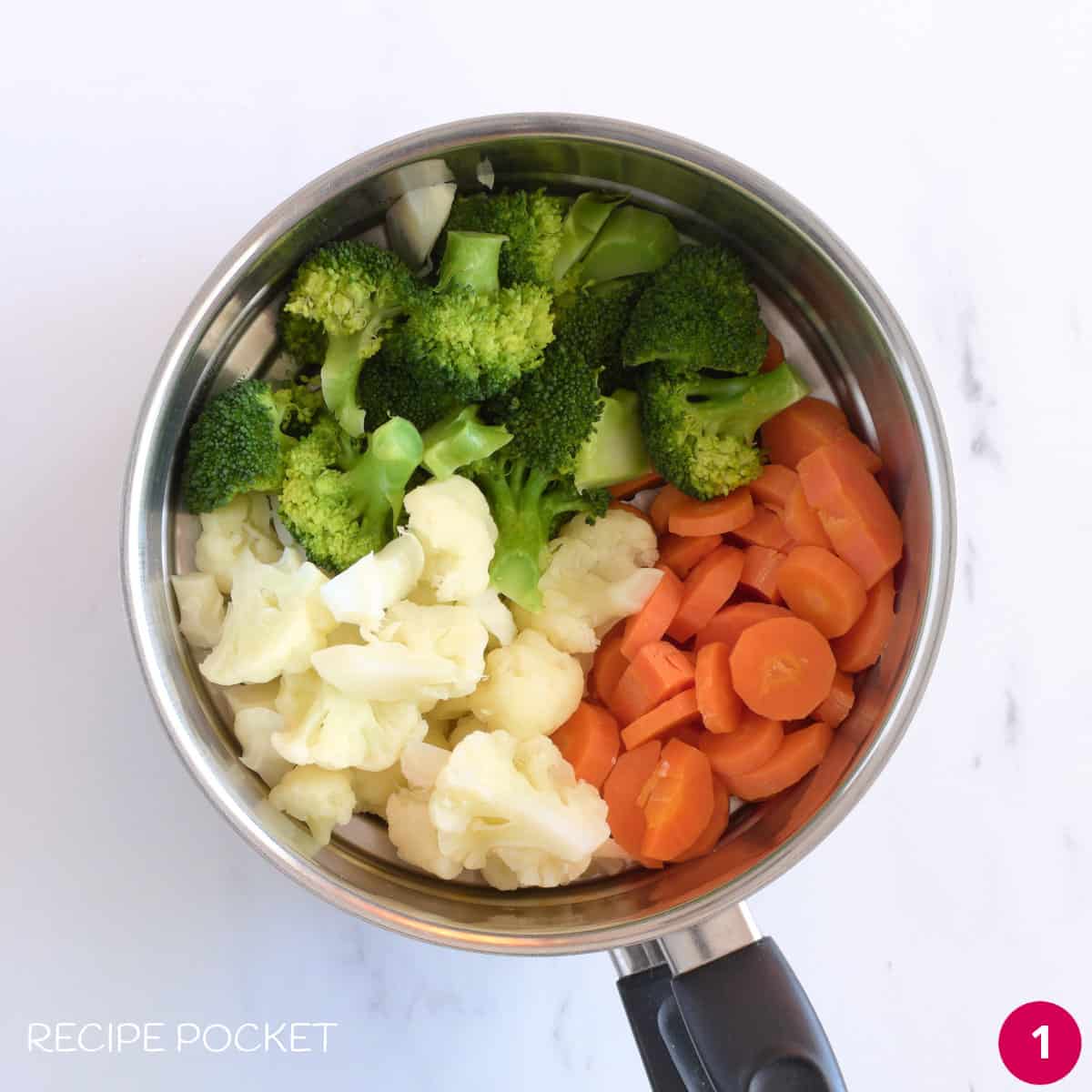 Carrots, cauliflower and broccoli in a steamer pot.
