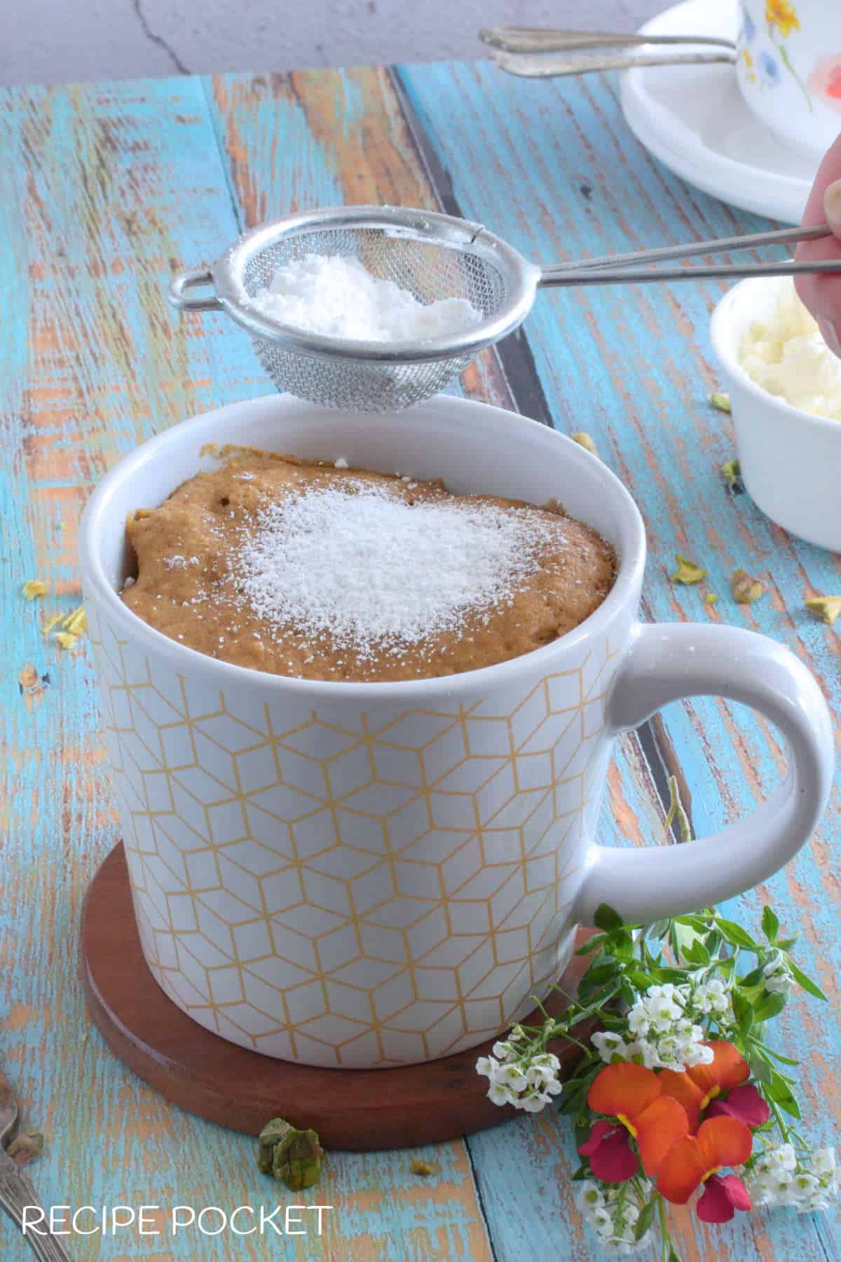 Gingerbread mug cake dusted with icing sugar.