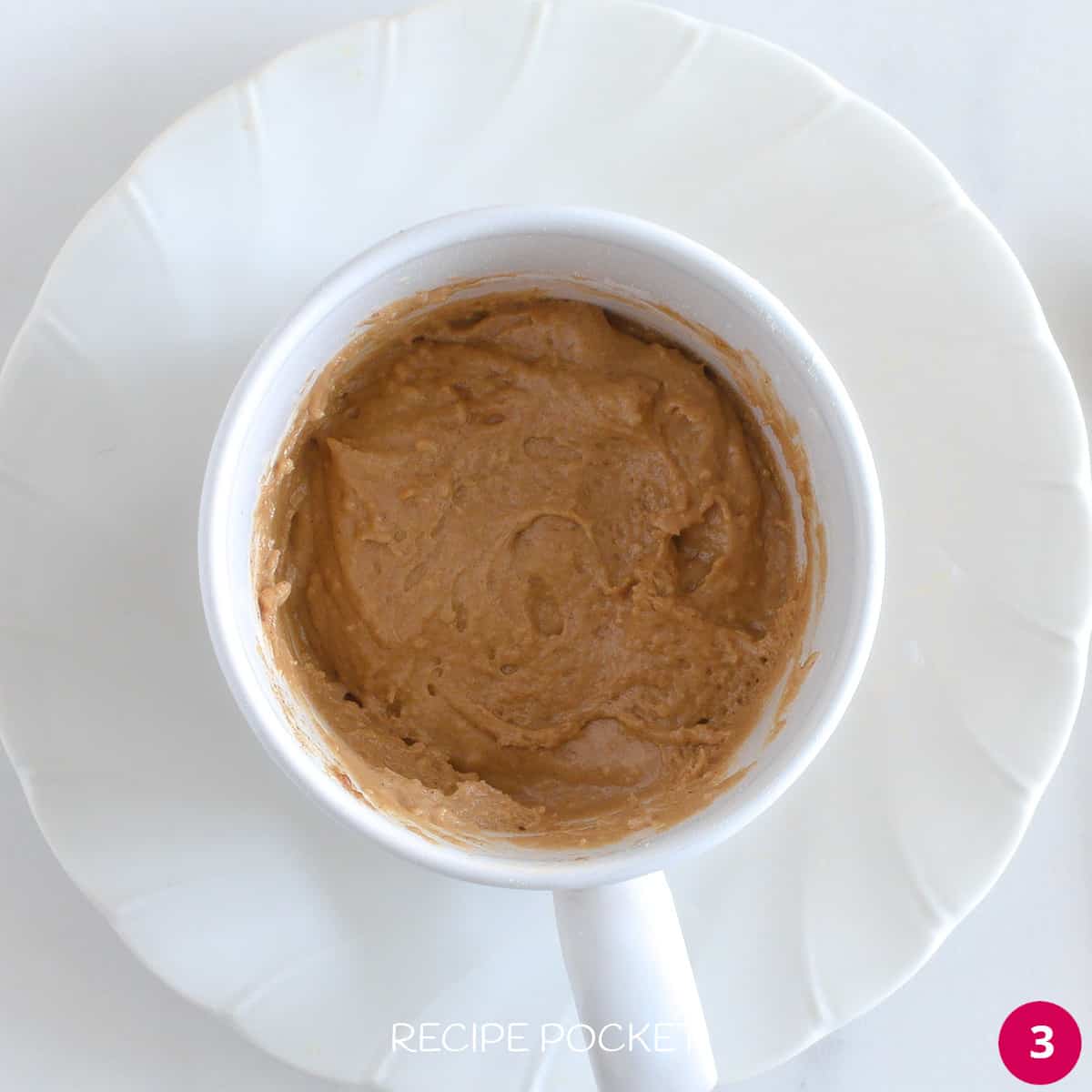 Uncooked cake batter in a mug.