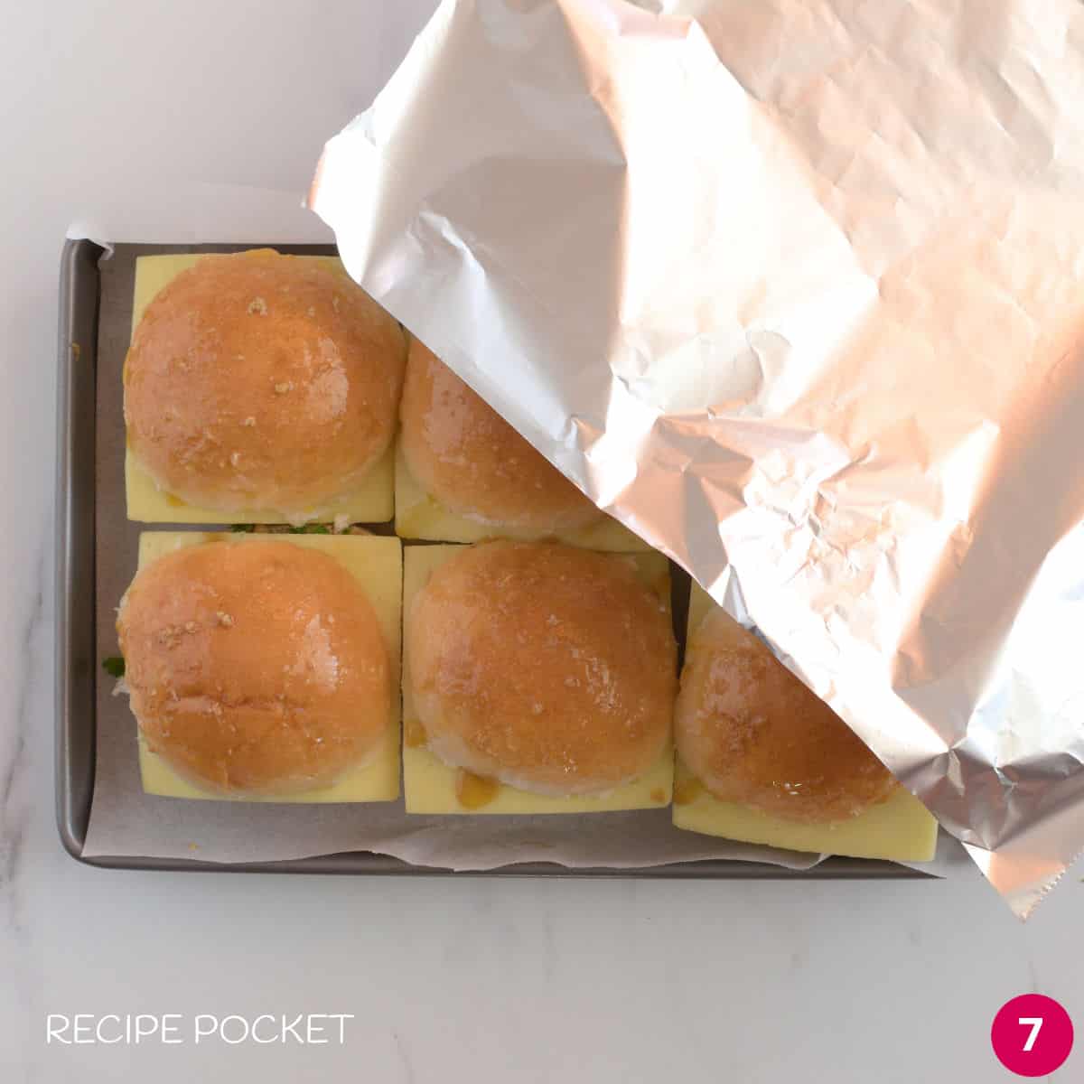 Prepared sliders on a tray covered with foil.