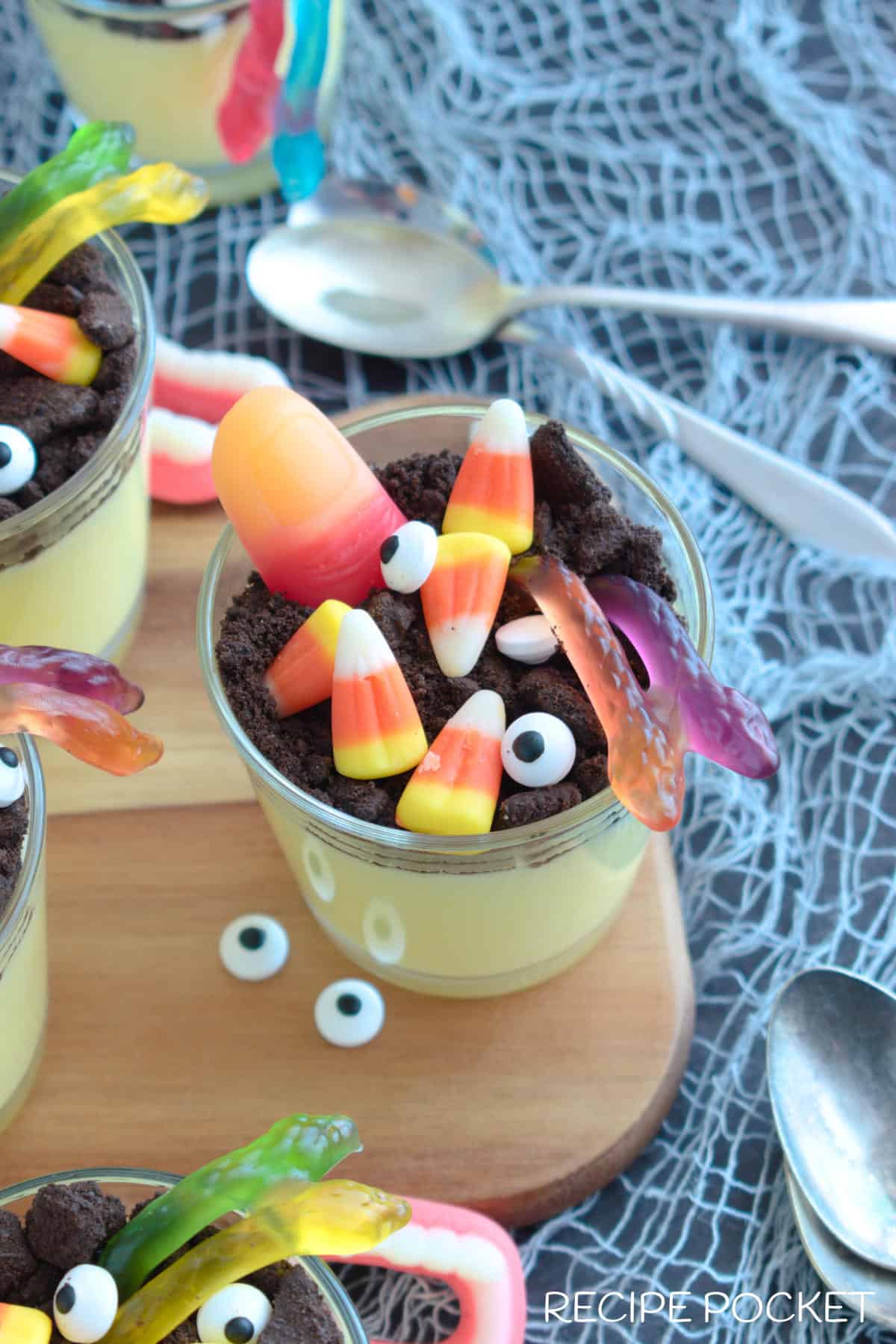 Vanilla pudding cups on a wooden board.
