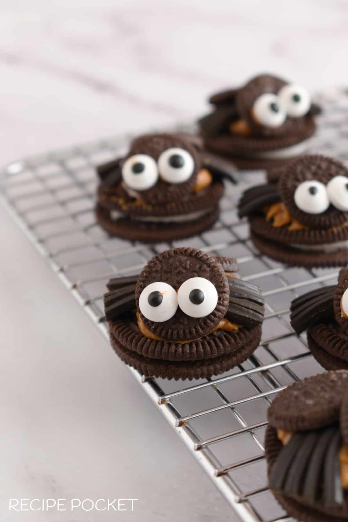 Oreo spider cookies on a wire rack.