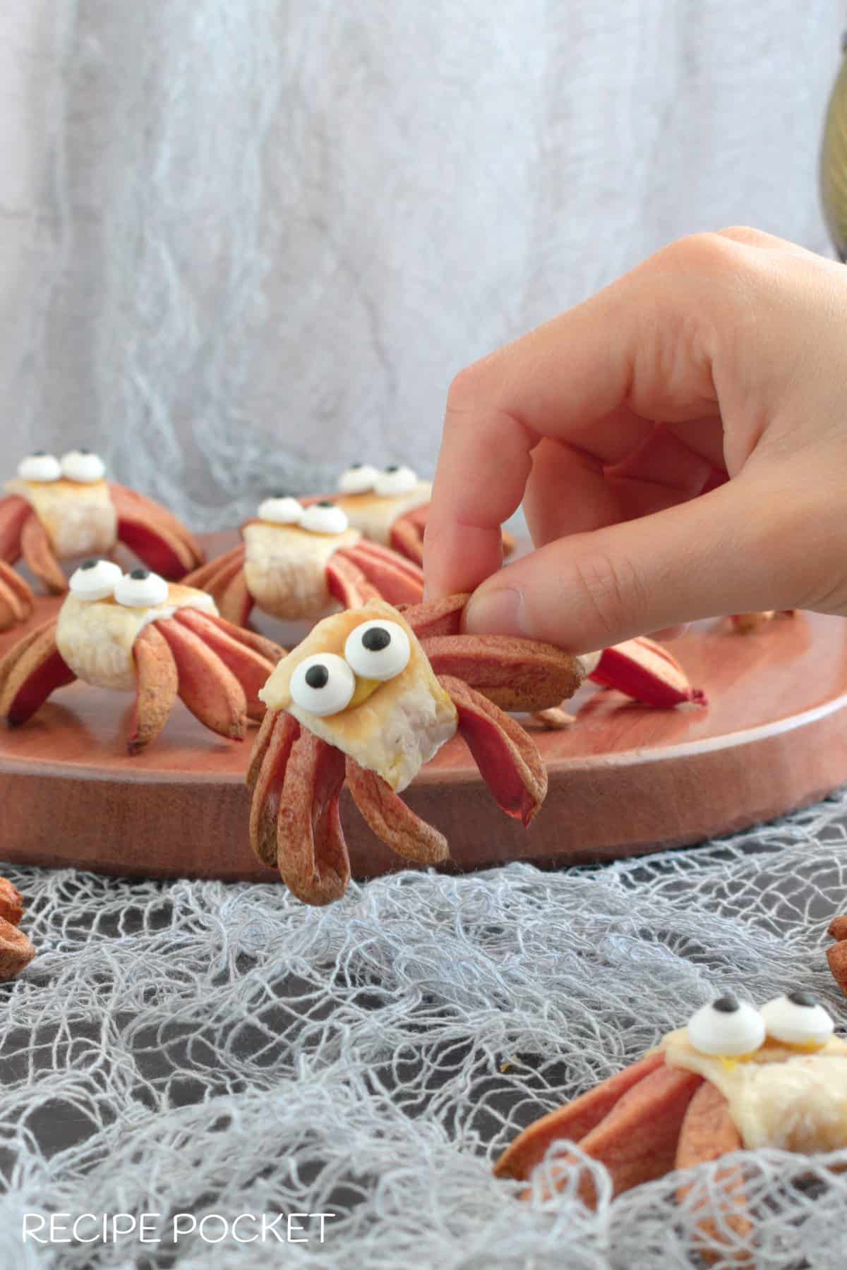 A hand holding a Halloween appetizer.