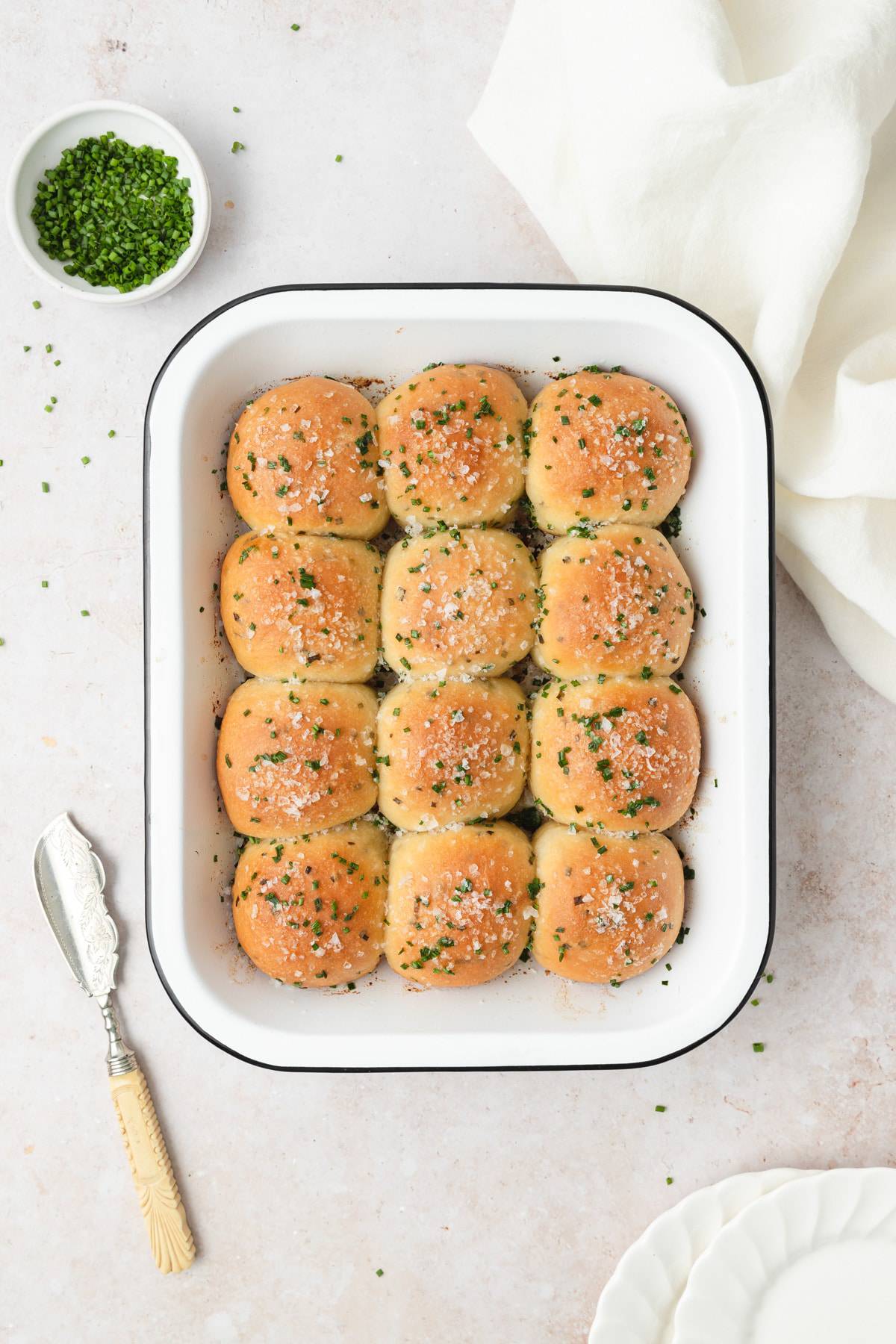 Sour cream and chives rolls in a white baking dish.
