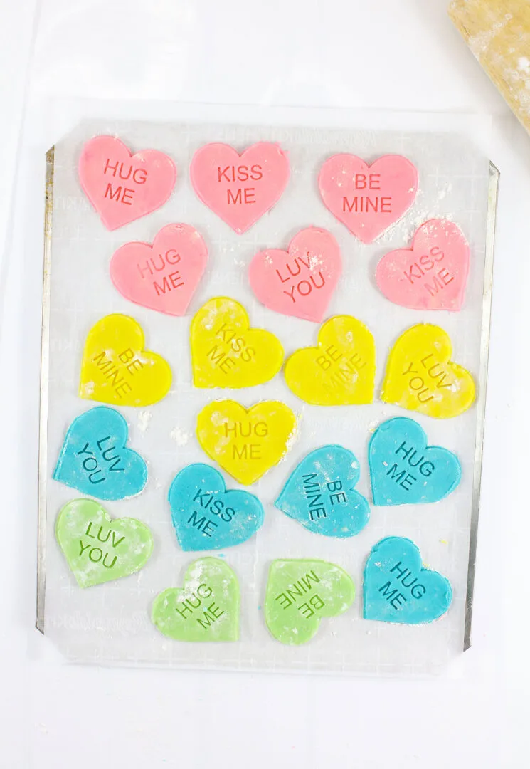 Pink, yellow, blue and green conversation heart cookies.